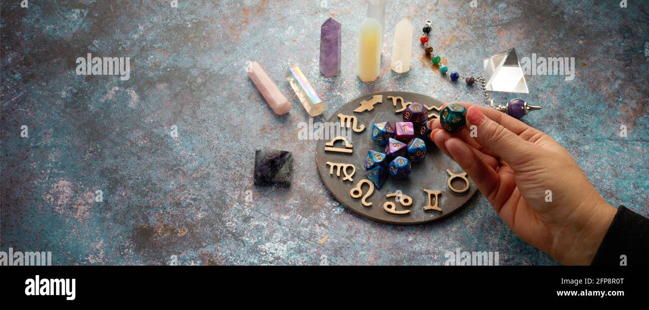 zodiac horoscope symbol with hands and healing crystals on rustic background