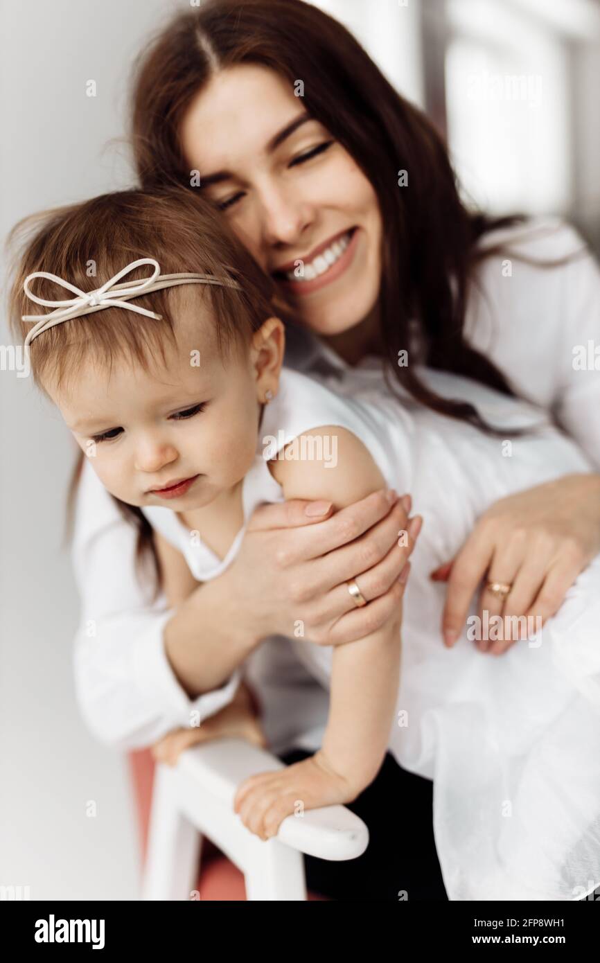 Happy brunette woman gently hugging beautiful baby girl, smiling ...