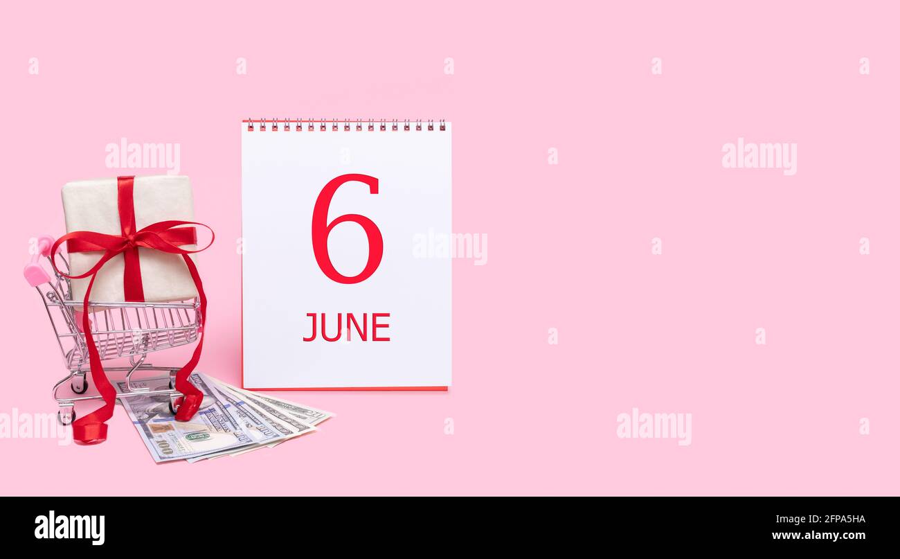 6th day of june. A gift box in a shopping trolley, dollars and a ...