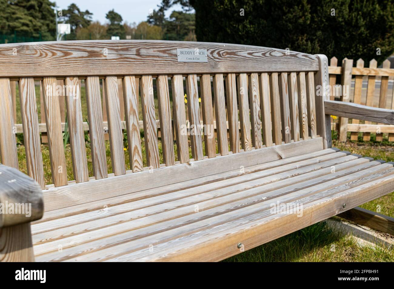 A buddy bench where friends or strangers can sit for a conversation and companionship. Friendship, loneliness, mental health concept Stock Photo