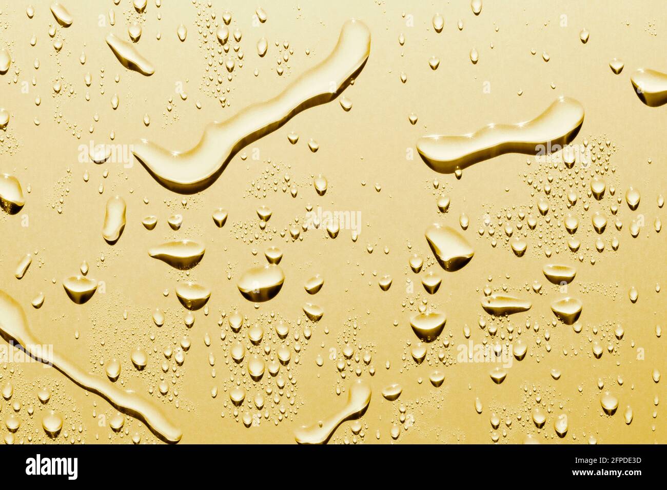 Close up of water drops on smooth surface, gold background Stock Photo ...