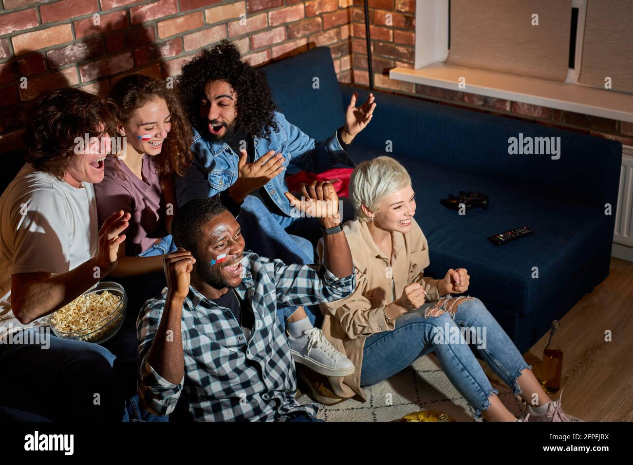 Young People Watching Sport Celebrating Goal, While Watching Competition On TV Online Translation. Cheering For Favourite Team, Entertainment Concept Stock Photo