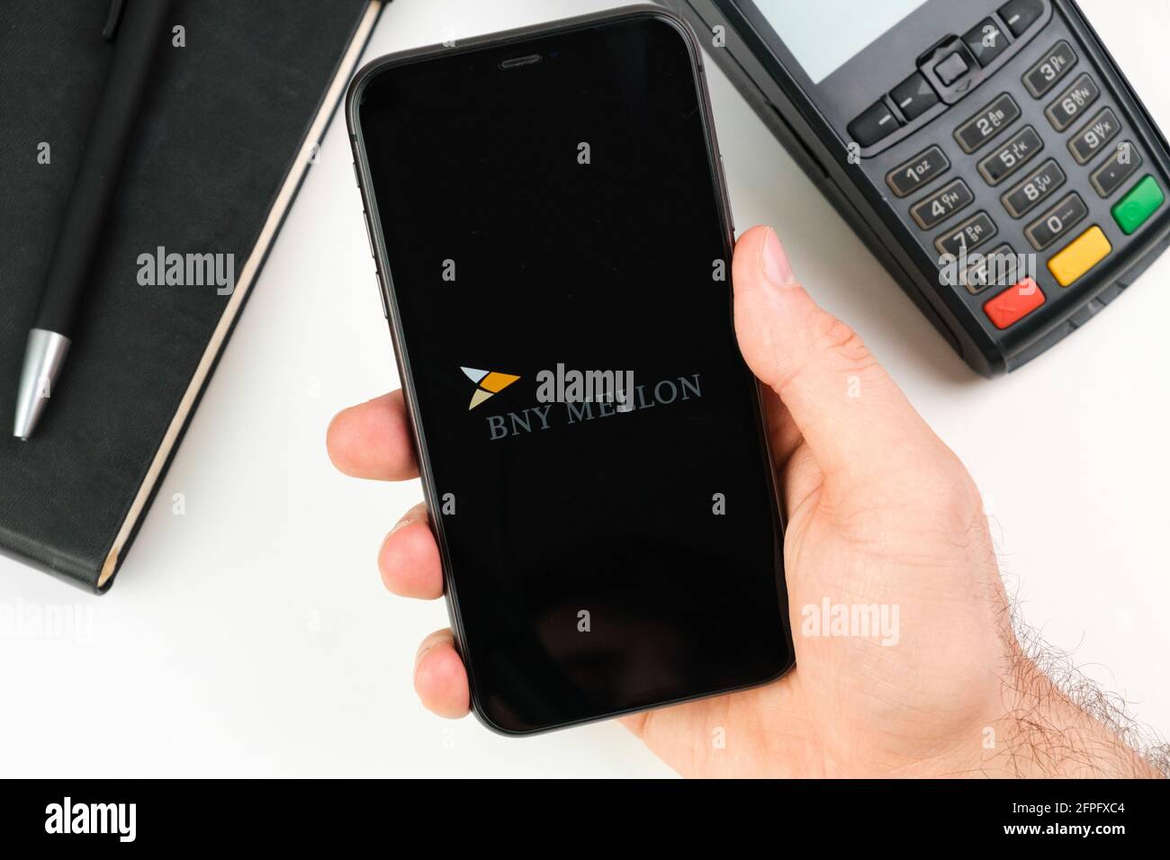BNY Mellon bank logo on the black smartphone screen in mans hand on the