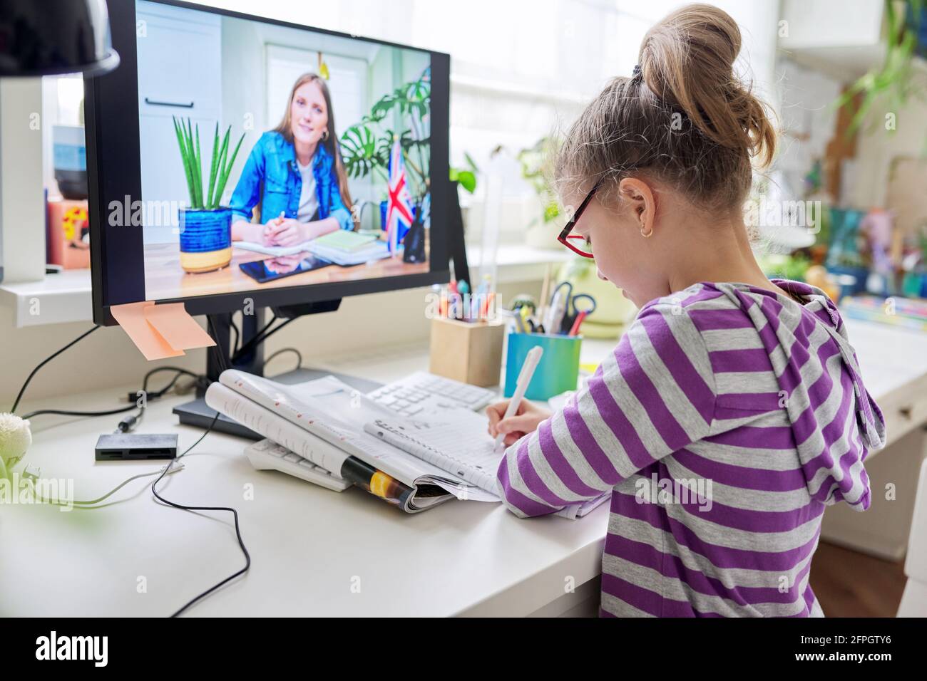 Online learning, little student girl learning language remotely with an ...