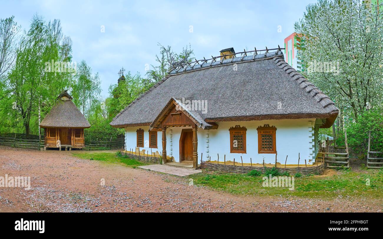Panorama of the Churchwarden's Estate with hata house, timber barn and a garden with blooming trees, Mamajeva Sloboda Cossack Village, Kyiv, Ukraine Stock Photo