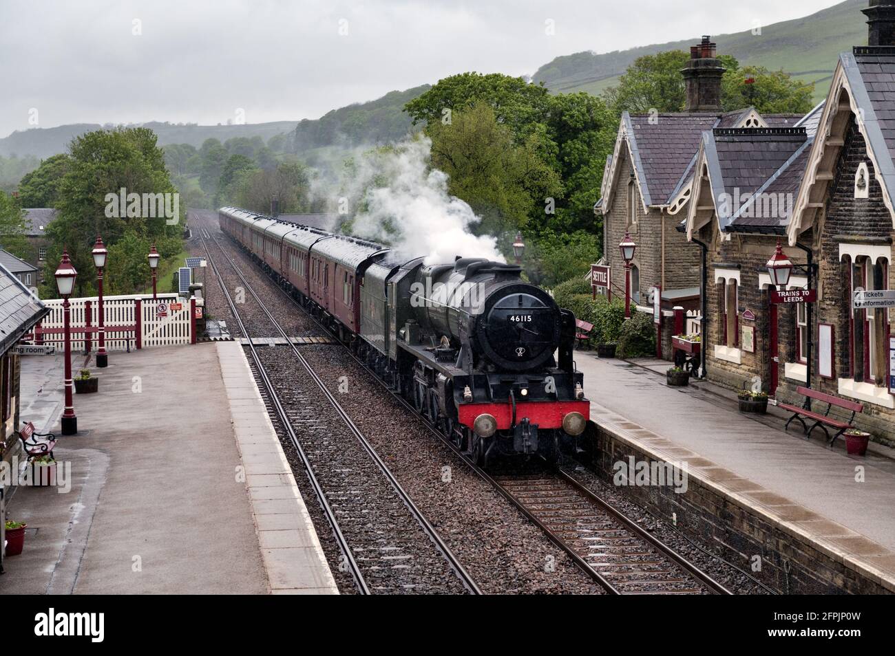 Steam locomotive 'Scots Guardsman' with 'The Dalesman' special, passing through Settle Station in the rain, returning from a trip to Carlisle. Stock Photo