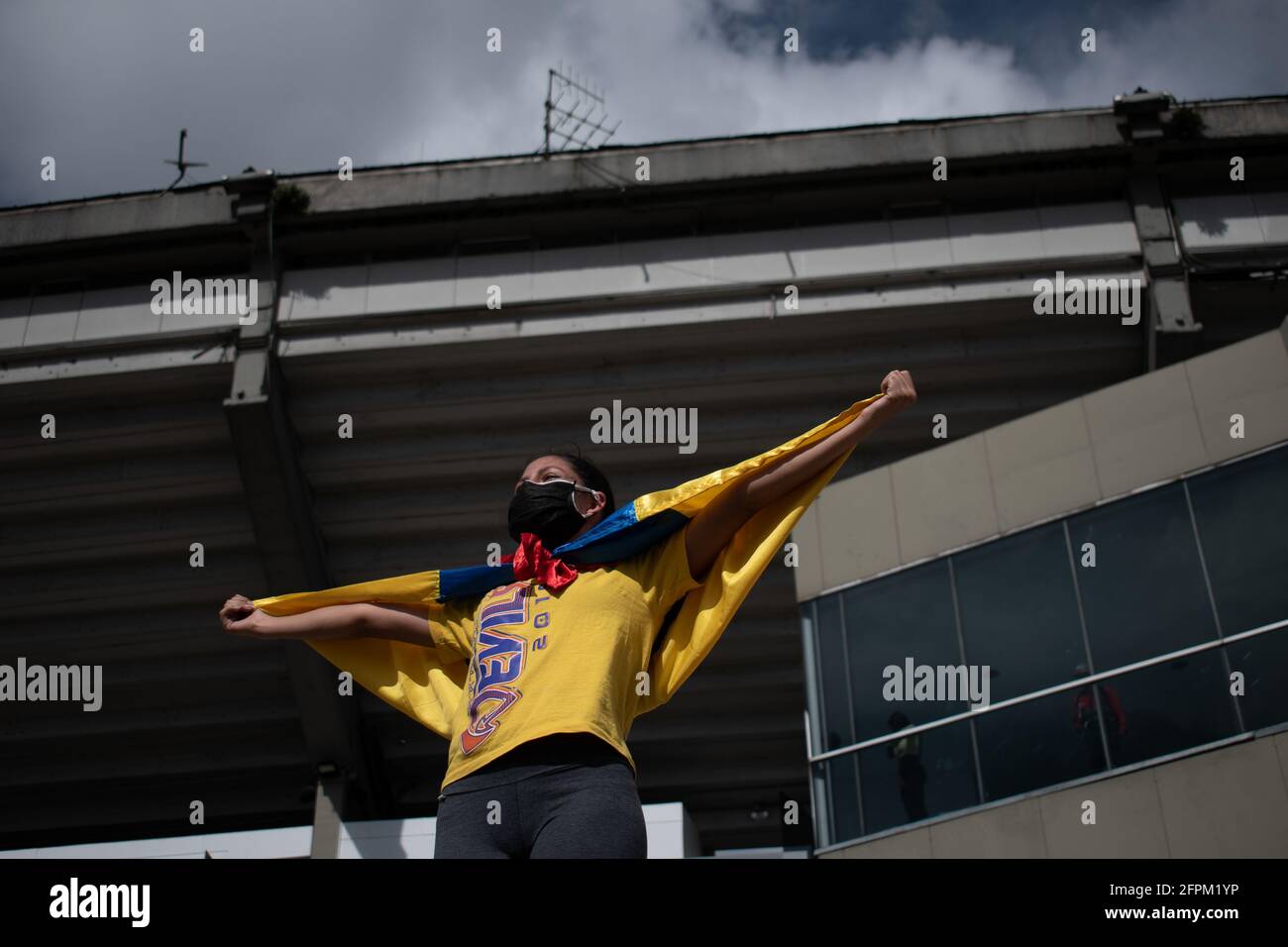 Bogota, Cundinamarca, Colombia. 19th May, 2021. Protester carries the Colombian flag on his back as the demonstrations increase in Bogota on May 20, 2021 in the context of a national strike in Colombia against the tax reform and the government of Ivan Duque. Credit: Daniel Romero/LongVisual/ZUMA Wire/Alamy Live News Stock Photo