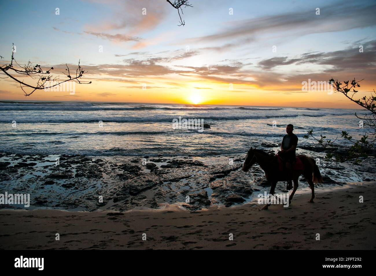 Horseback riding on beach in Costa Rica Stock Photo