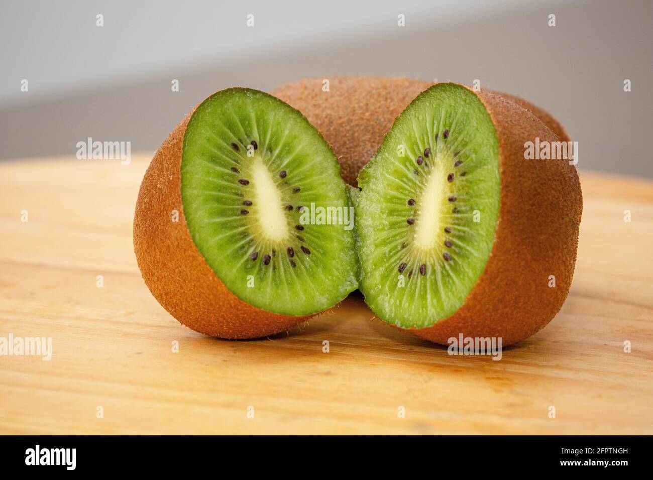 Ripe brown sliced kiwi on table ready for morning vitamin. Stock Photo