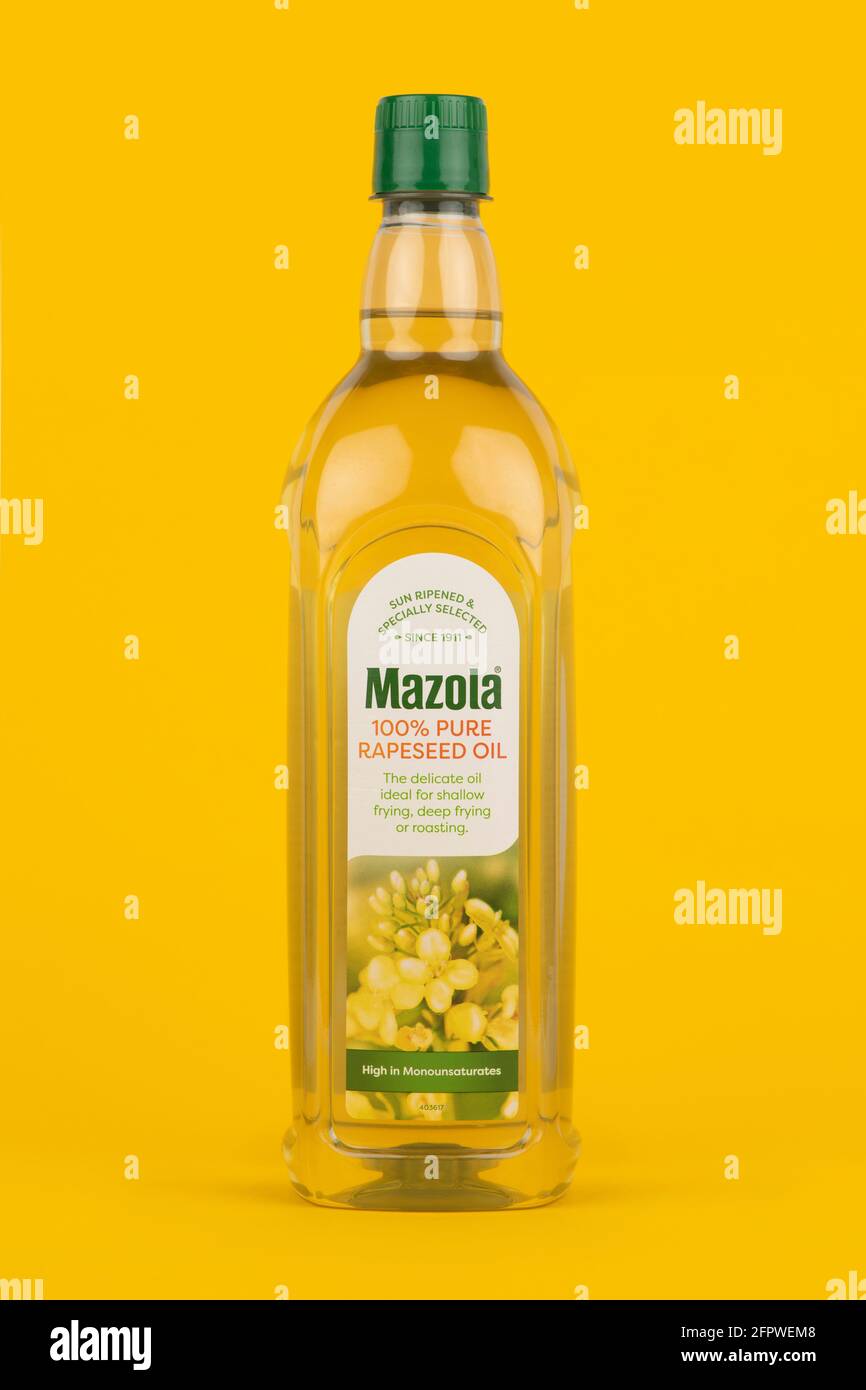 A bottle of Mazola 100& pure rapeseed oil shot on a yellow background. Stock Photo