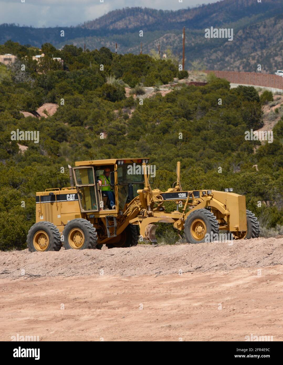 A heavyequipment operator uses a Caterpillar 120H Motor Grader to move