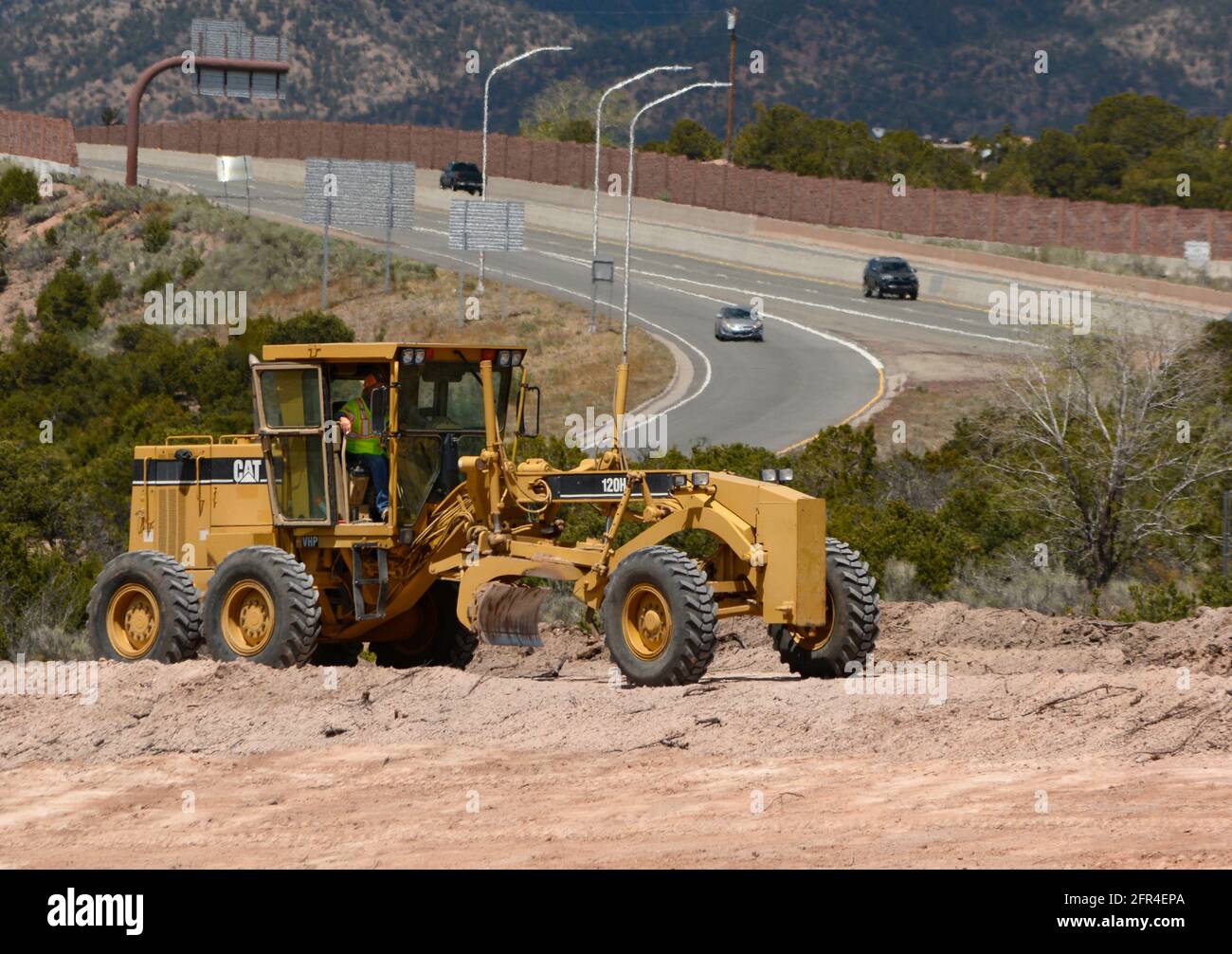 A heavyequipment operator uses a Caterpillar 120H Motor Grader to move