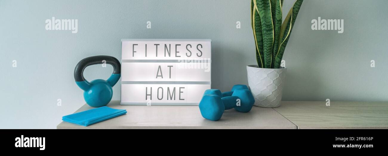 Workout at home fitness gym online class exercise with dumbbell weights, resistance bands. Coronavirus COVID-19 sign lightbox banner training indoors Stock Photo