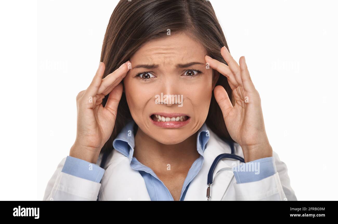 Funny facial expression doctore feeling bad for medical malpratice mistake. Stressed anxious Asian woman with headache Stock Photo