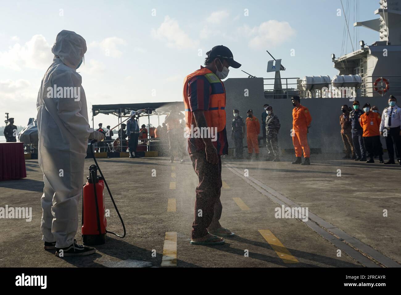 Badung, Bali, Indonesia. 21st May, 2021. Indonesian fishermen rescued from the sunken vessel disinfected due to the health protocol. Repatriation process of fishermen from Australian HMAS Anzac to Indonesian