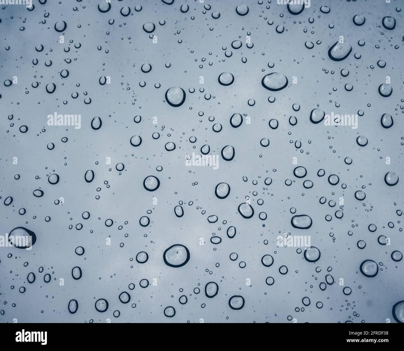 Rain droplets on a window during a spring rain storm Stock Photo