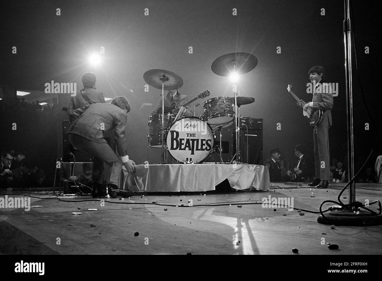 The Beatles performing at the Washington Coliseum in their first American concert on February 11, 1964. The stage is littered with jelly beans from fans pelting the band with them after a New York newspaper reported the band discussing a like for them. (USA) Stock Photo