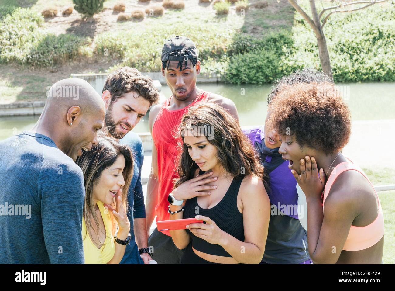 Group of runners very surprised when looking at something on a mobile. Stock Photo