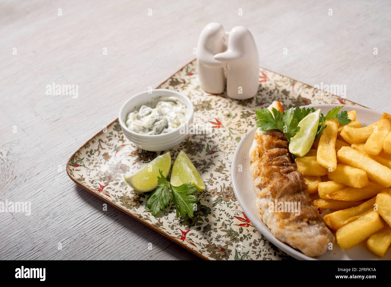 Fish and chips with lemon, parsley and tartar sauce Stock Photo