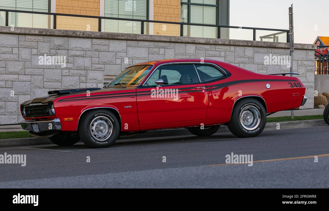 Street view of the vintage Plymouth Duster classic car parked on the sideway of the street. April 18,2021-Guilford, BC,Canada. Travel photo, street vi Stock Photo