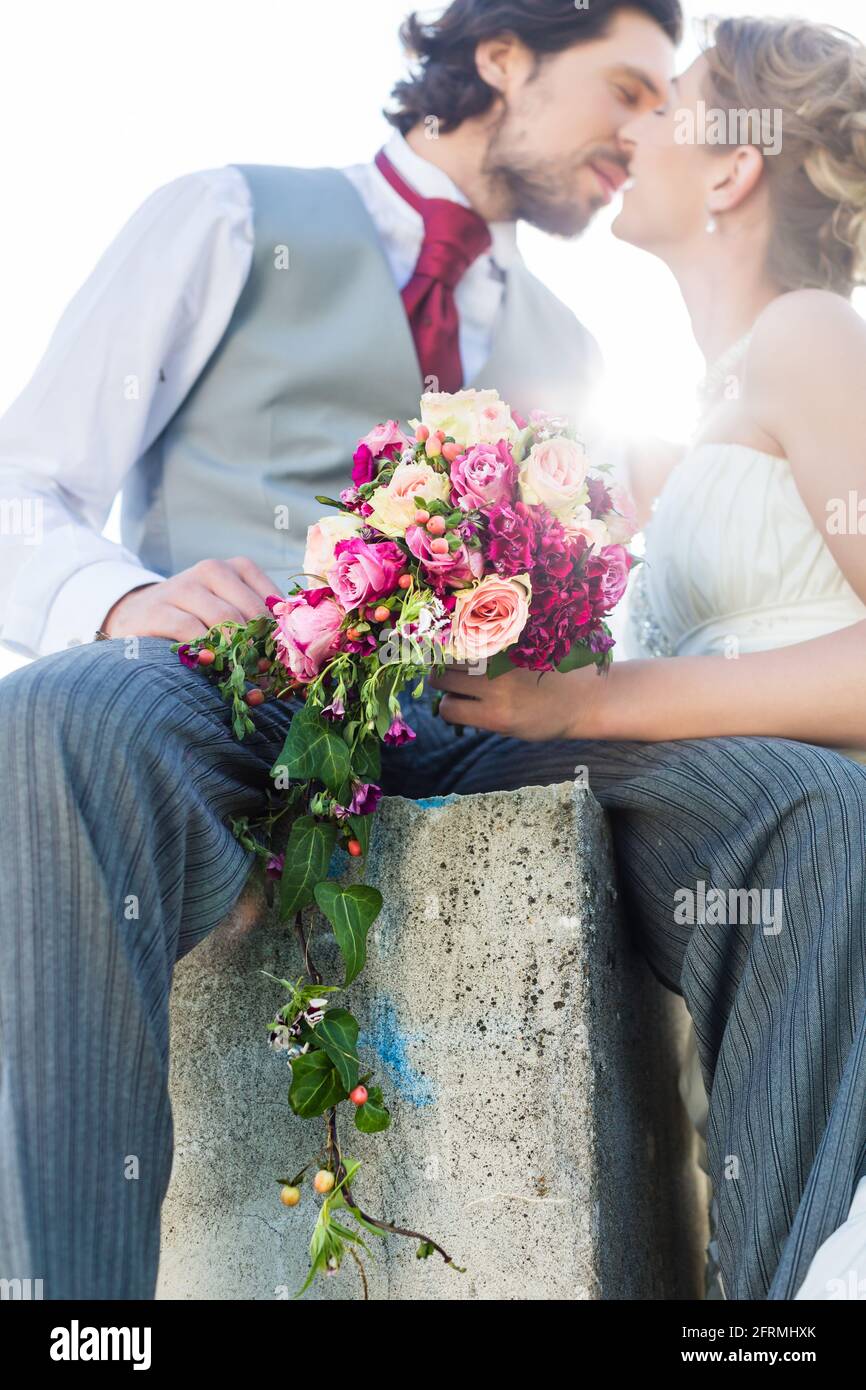 Bridal pair kissing on field after wedding Stock Photo