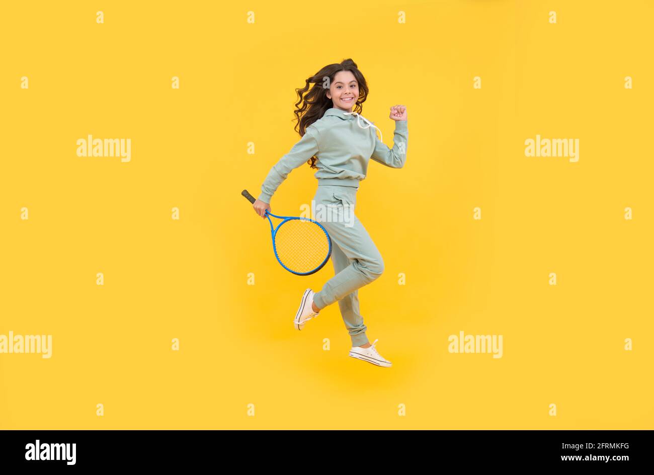 happy energetic kid jump in sportswear with squash racquet running to success, stamina. Stock Photo