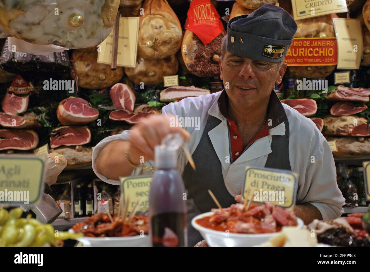 Delicatessen and dry cured meat seller in the central market in Florence, Tuscany , Italy Stock Photo