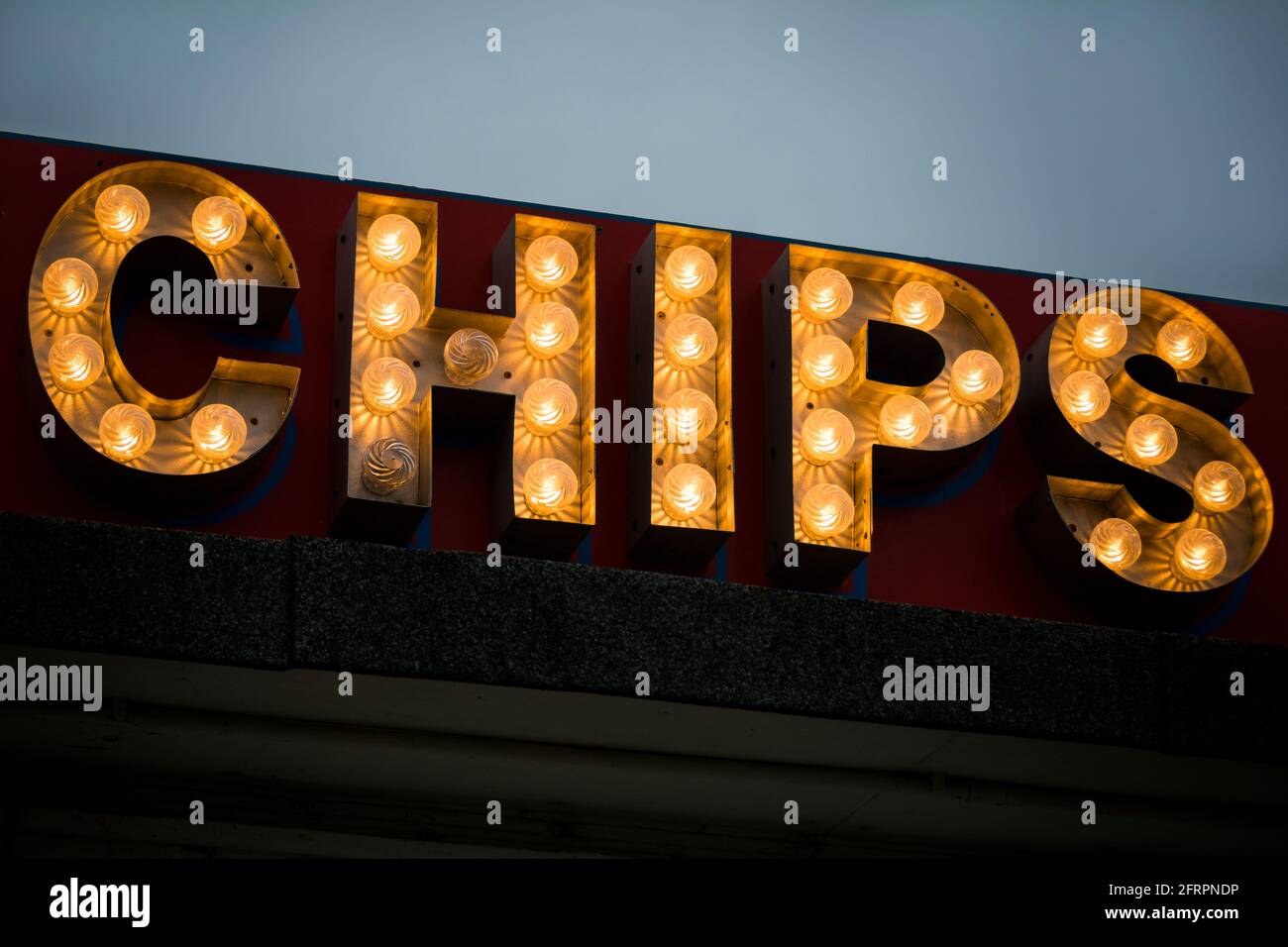 Illuminated sign at seaside fish and chip shop after dark Stock Photo