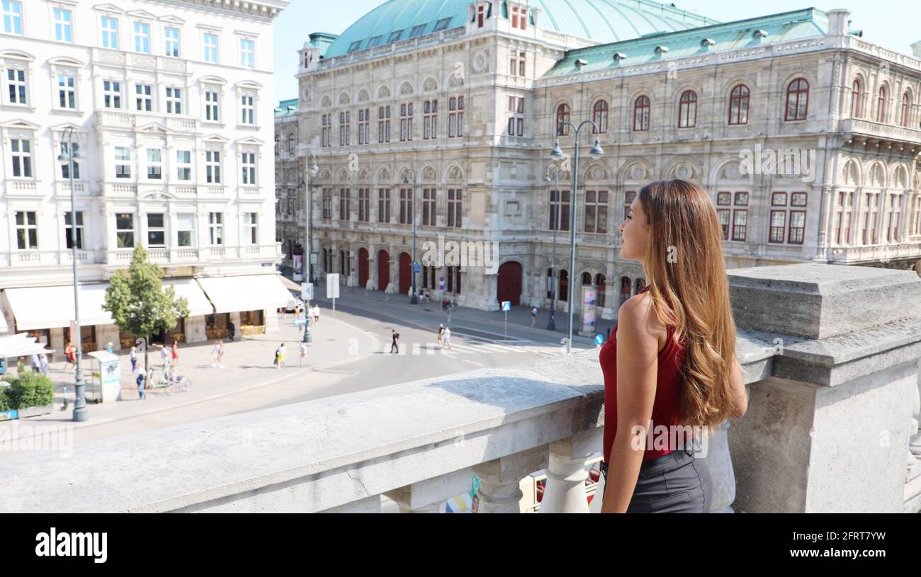 Tourism in Vienna, Austria. Back view of beautiful girl enjoying visiting the city of Vienna with famous historic palaces State Opera and Hotel Sacher Stock Photo