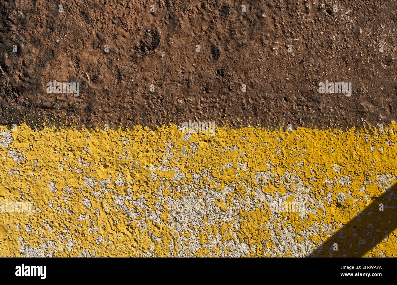 old house concrete wall background with crumbling brown and yellow