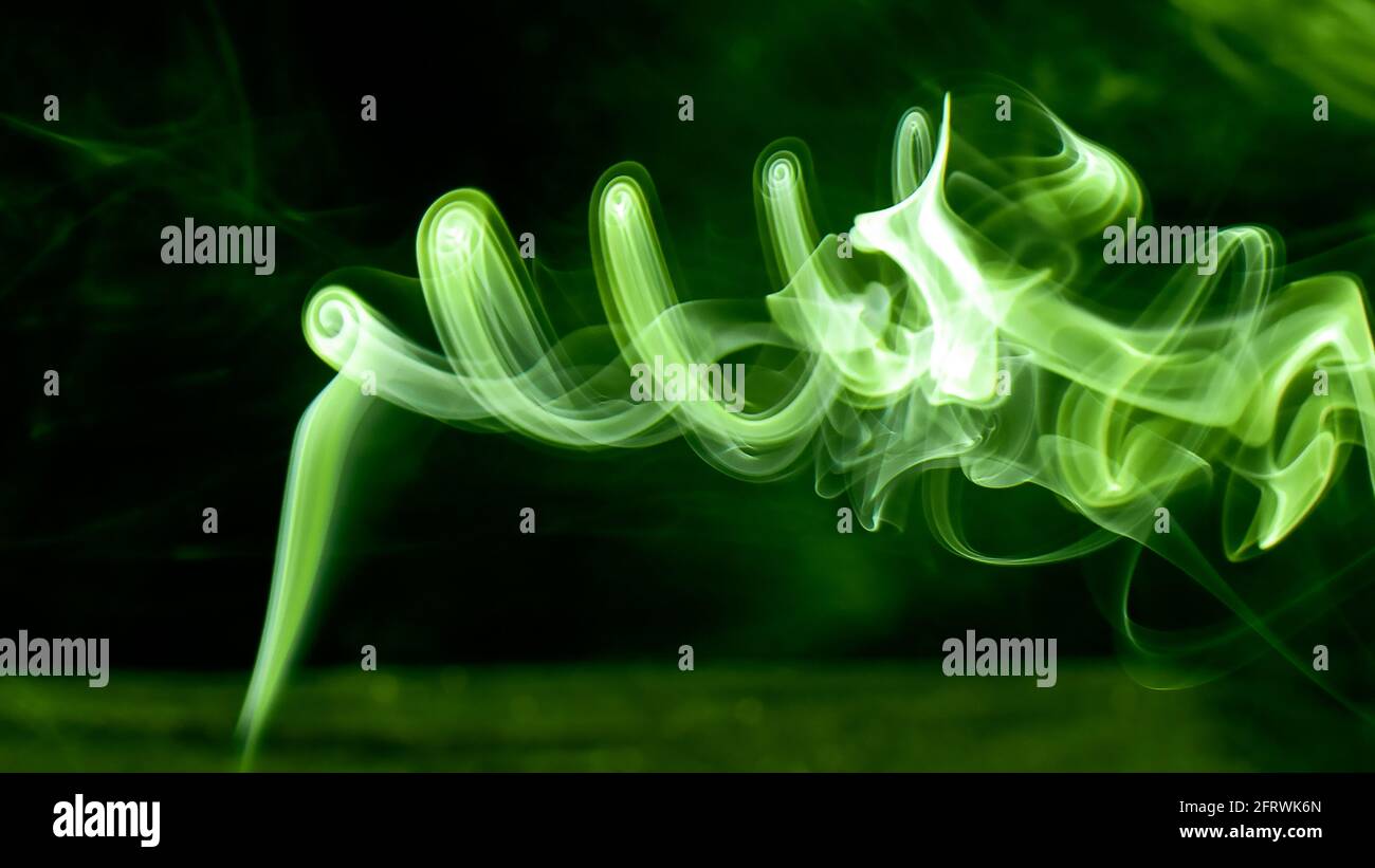 Bright green luminescent smoke revolves in a mystical vortex. Fantasy and magic photography. Great photo for your computer wallpaper or phone desktop. Stock Photo