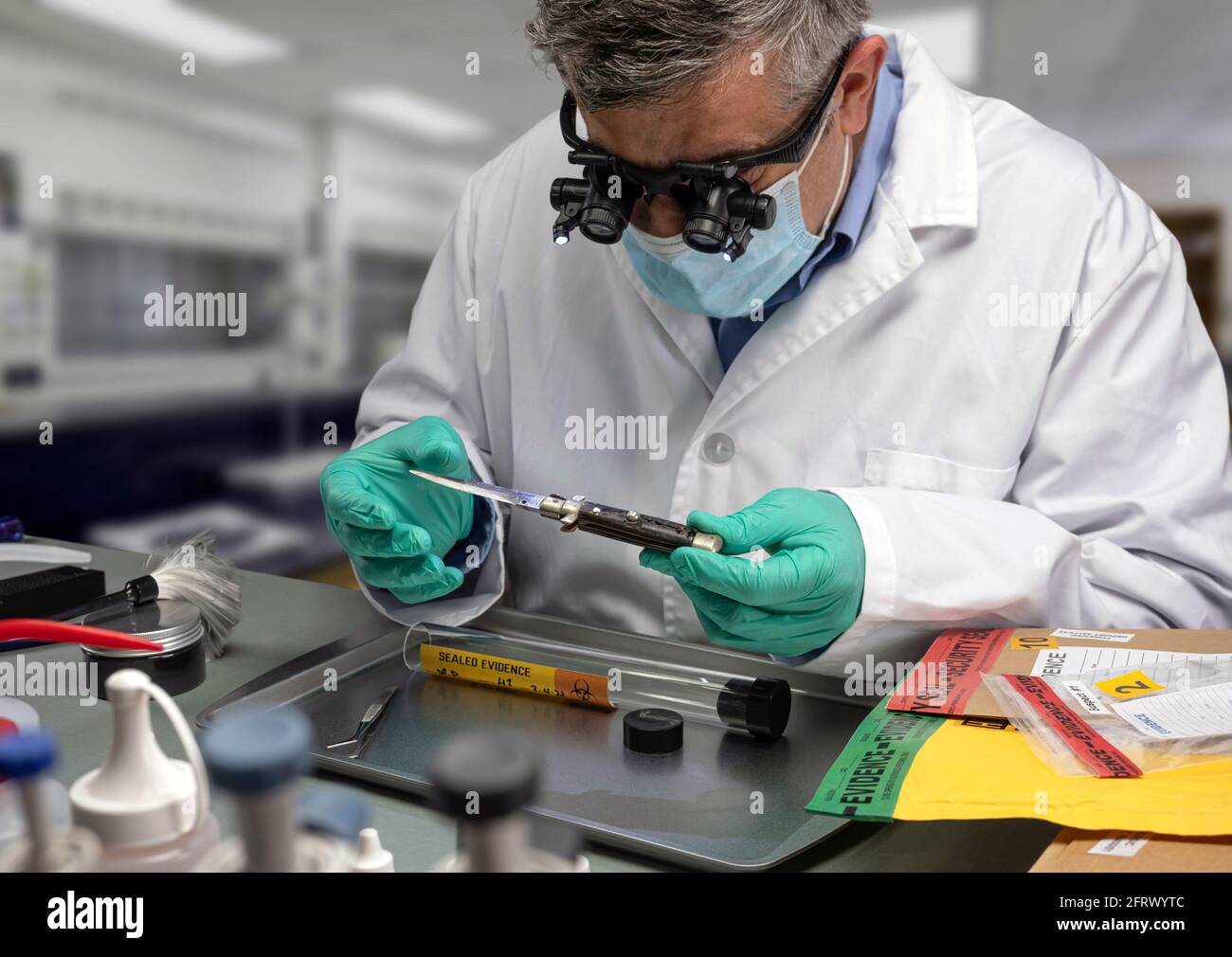 Forensic police analyse knife used in murder at crime lab with magnifying glasses, concept image Stock Photo