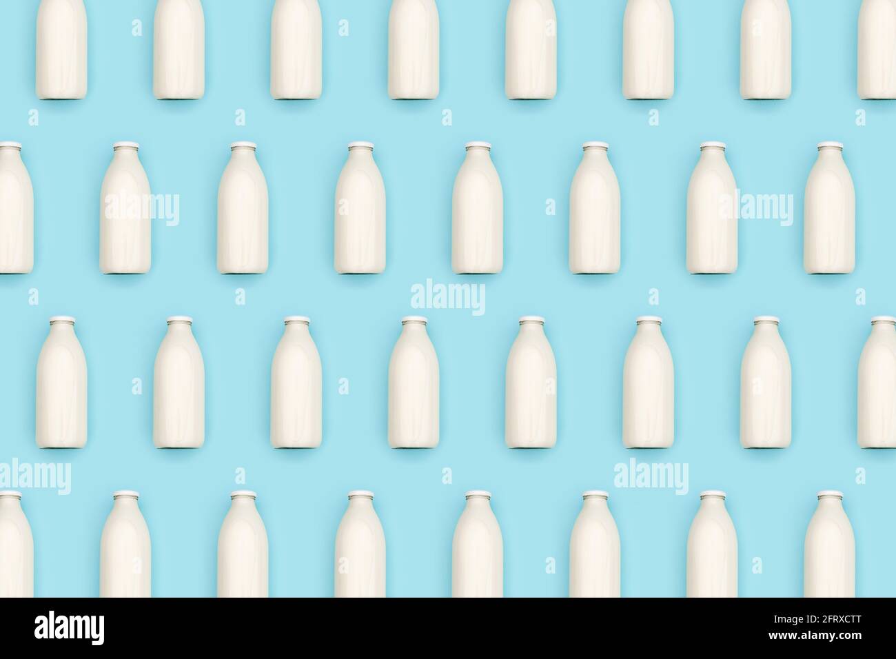 Pattern made with transparent glass bottle of milk on blue background. Flat lay Top view. Stock Photo