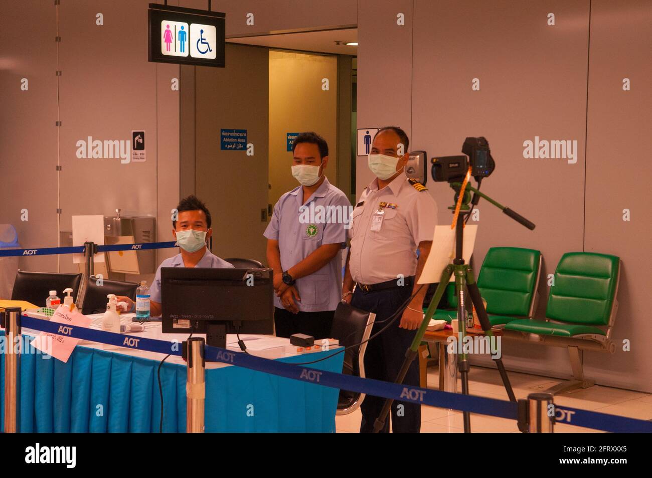 2 Thai health officials & a security guard, wearing protective face