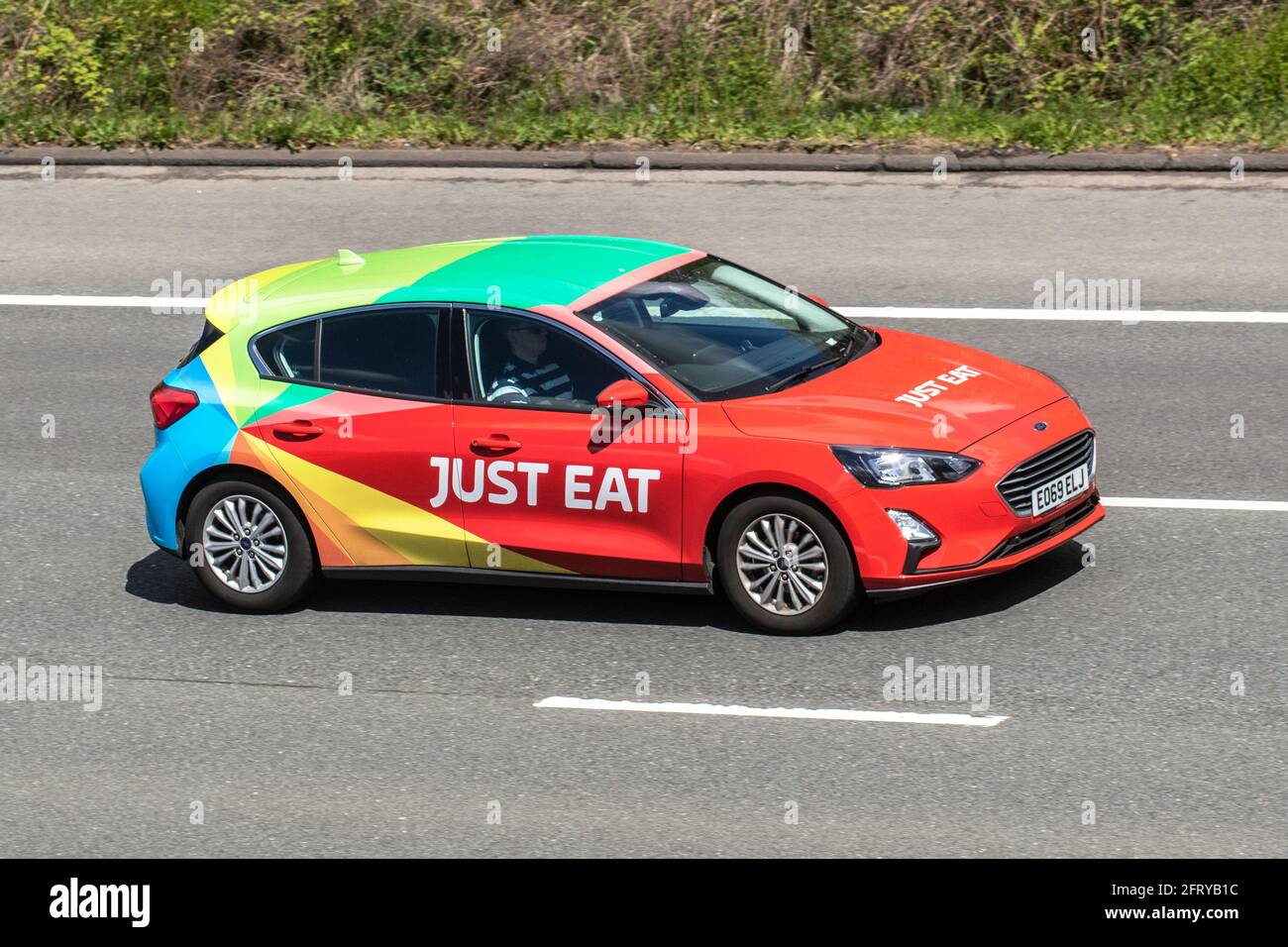 Just Eat 2019 Ford Focus Titanium Tdci red diesel hatchback; Vehicular traffic moving vehicles, catering commercial vans, foods courier on the Just Eat network, takeaway food business vehicle, livered cars driving vehicle on UK roads, motors, motoring on the M6 motorway highway network. Stock Photo