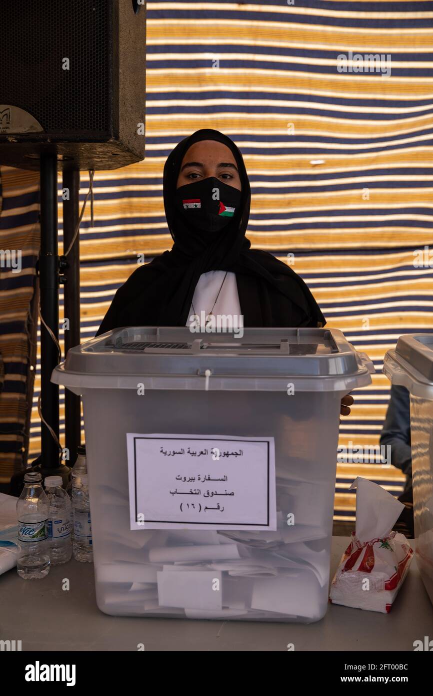 Beirut, Lebanon. 20th May 2021. Syrian poll worker Rim Alkhalaf guards a ballot box as Syrian nationals living in Lebanon arrive at the Syrian Embassy in Yarze, east of Beirut, to cast their votes in the country’s presidential election. The expat ballot started in embassies abroad ahead of Syria’s May 26 presidential election. Credit: Chris Trinh Stock Photo