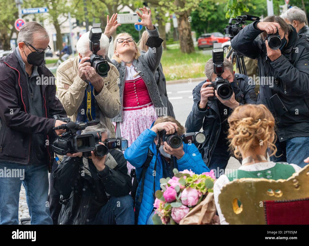21 May 2021, Bavaria, Munich: Sarah Jäger sits on a throne surrounded by photographers during her coronation as Bavarian Beer Queen 2021/2022. Jäger is the first beer queen from the Upper Palatinate after eleven years, according to the Bavarian Brewers Association. Photo: Peter Kneffel/dpa Stock Photo