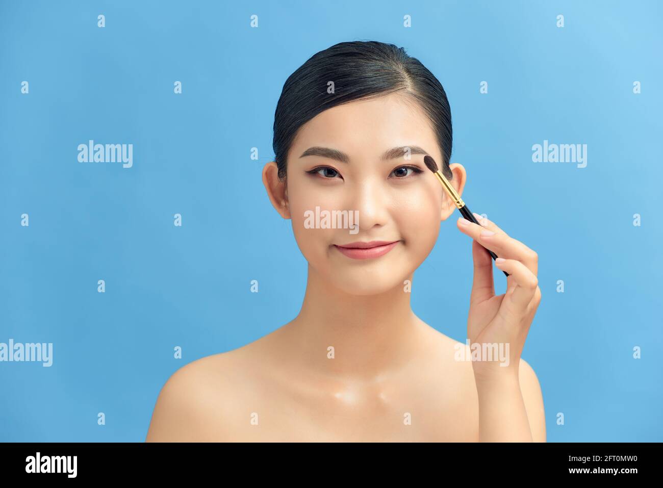 Beautiful and professional make up artist using brush and blusher Stock Photo