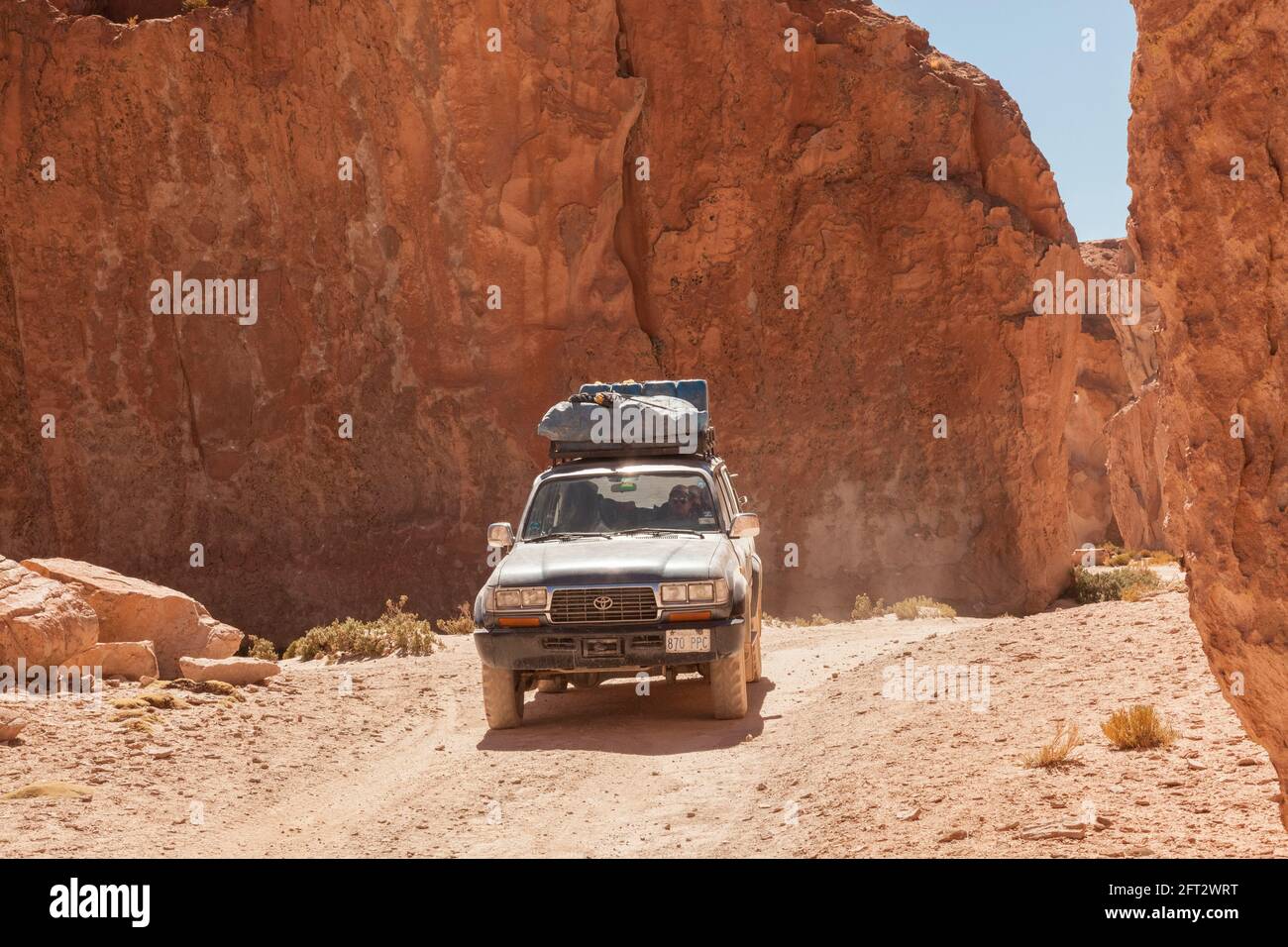 An SUV 4x4 vehicle negotiates a rocky canyon in the Bolivian desert Stock Photo