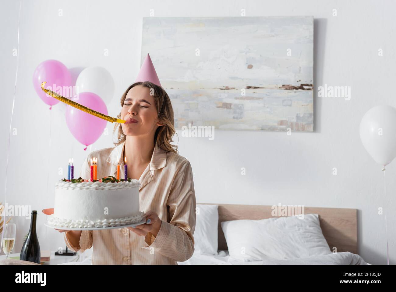Young woman blowing party horn hi-res stock photography and images - Alamy