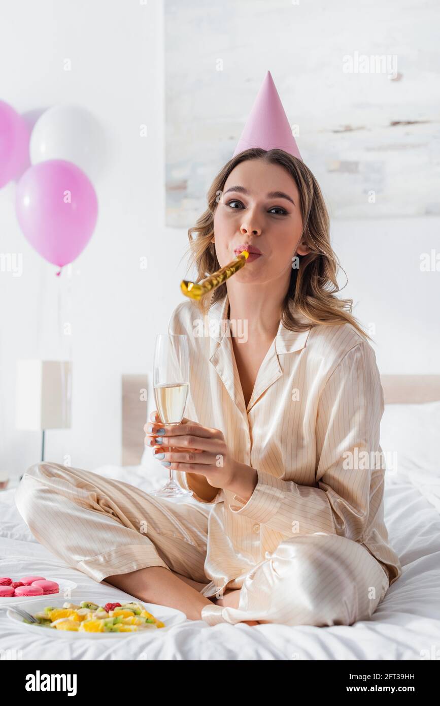 Young woman blowing party horn hi-res stock photography and images - Alamy