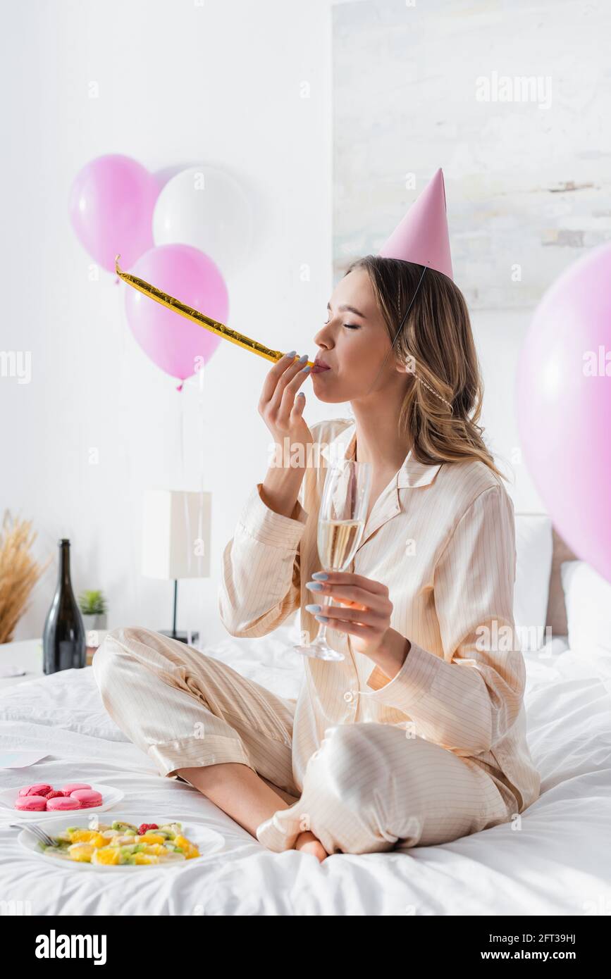 Young woman blowing party horn hi-res stock photography and images - Alamy