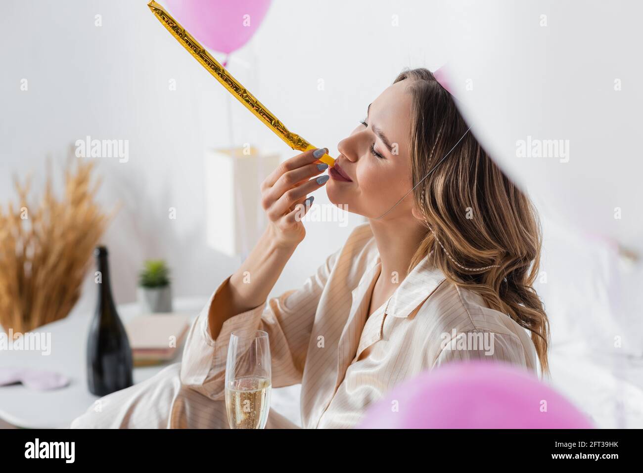 Young woman blowing party horn hi-res stock photography and images - Alamy