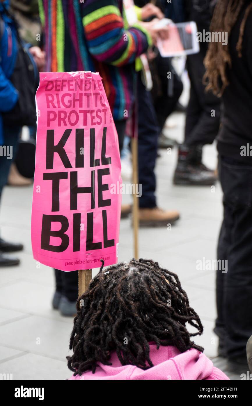 Sheffield, UK: 1st May 2021 : Kill The Bill – BAME woman sits with a pink Kill The Bill placard at at the Kill the Bill protest, City Hall steps, Bark Stock Photo