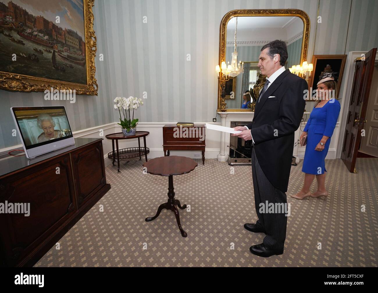 Queen Elizabeth II appears on a screen by videolink from Windsor Castle, where she is in residence, during a virtual audience to receive His Excellency Dr Cesar Rodriguez-Zavalla, the Ambassador of Uruguay, and his wife Maria Angelica Algorta-Carrau, at Buckingham Palace, London. Picture date: Friday May 21, 2021. Stock Photo