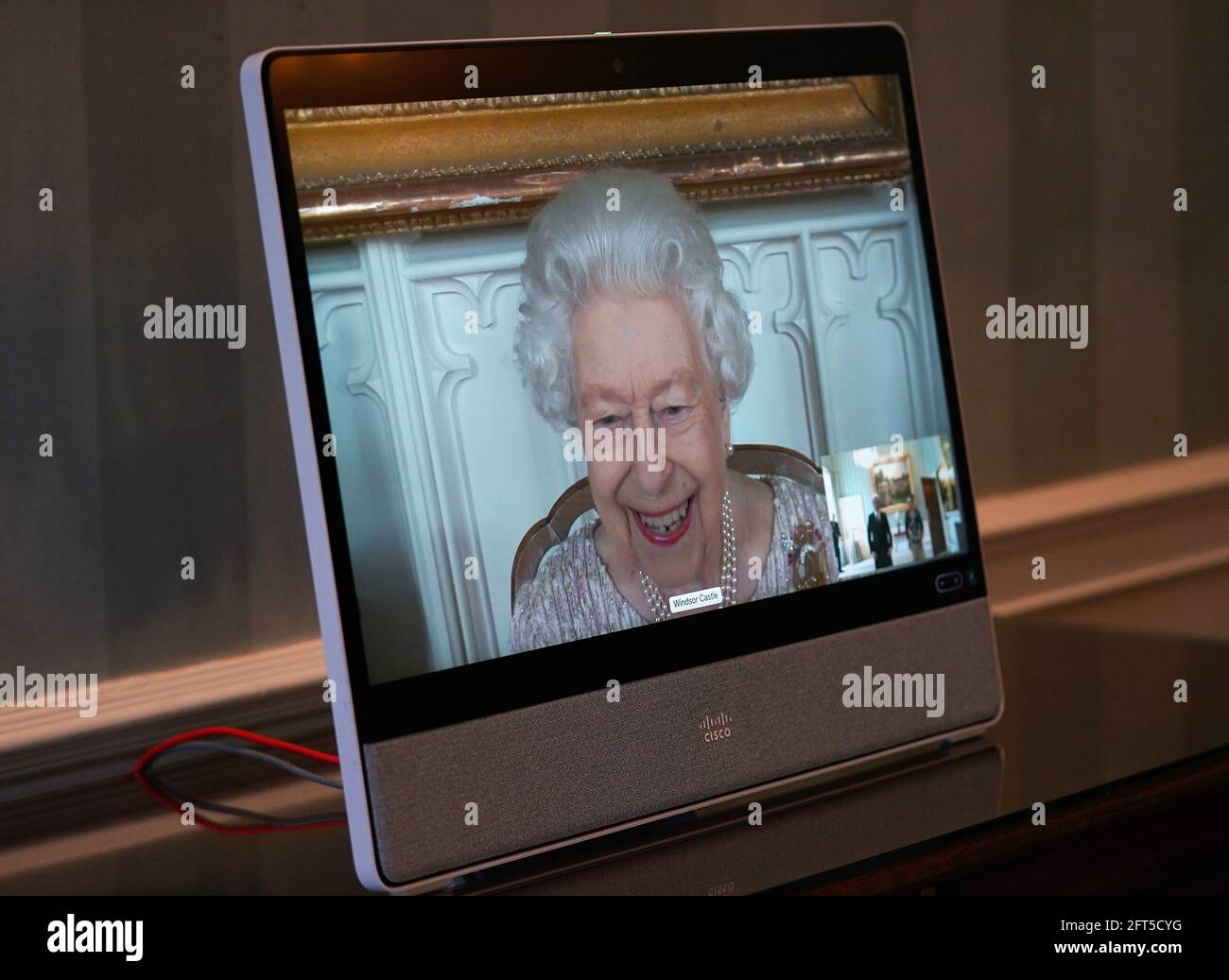 Queen Elizabeth II appears on a screen by videolink from Windsor Castle, where she is in residence, during a virtual audience to receive His Excellency Lim Tuan Kuan, the High Commissioner for the Republic of Singapore, and his wife Patricia Teh, at Buckingham Palace, London. Picture date: Friday May 21, 2021. Stock Photo