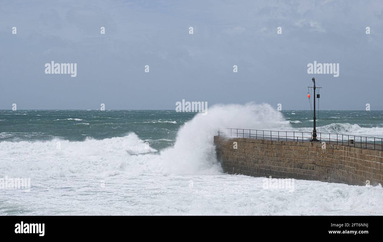 Porthleven, Cornwall, UK. 21st May 2021. UK Weather. Gale force winds battered the coast of Cornwall at Porthleven today, with large areas of the harbour swamped with sea foam. Credit CWPix / Alamy Live News. Stock Photo