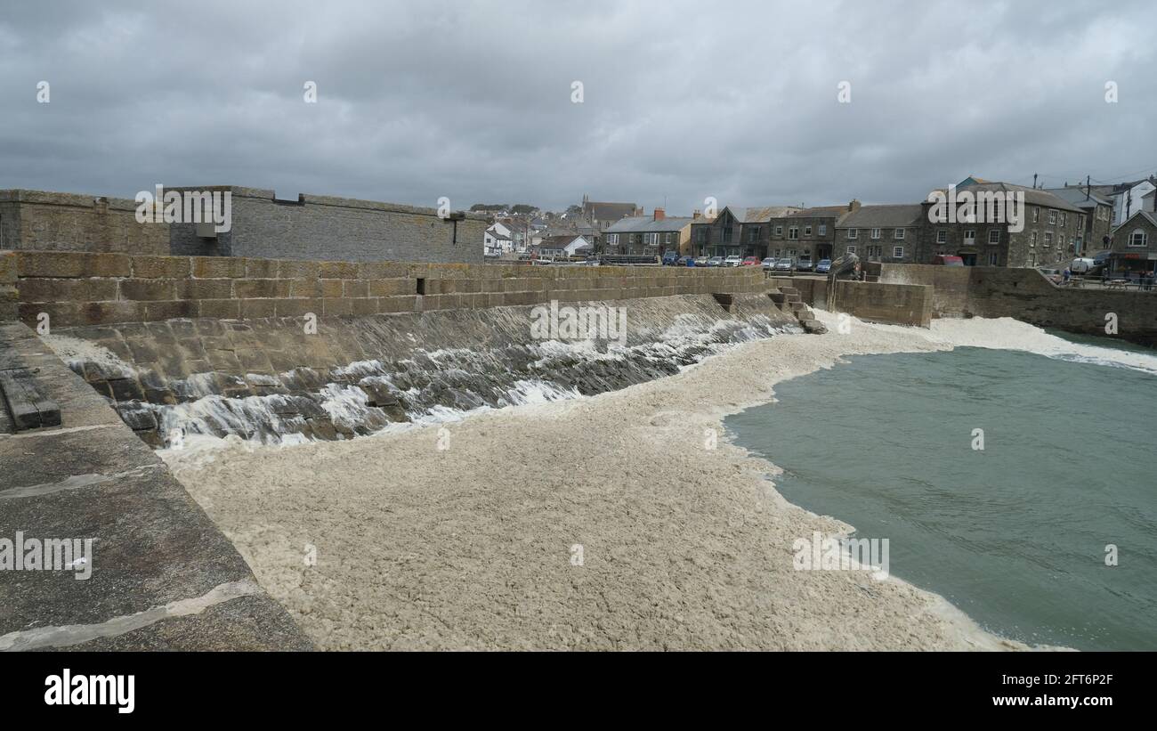 Porthleven, Cornwall, UK. 21st May 2021. UK Weather. Gale force winds battered the coast of Cornwall at Porthleven today, with large areas of the harbour swamped with sea foam. Credit SImon Maycock / Alamy Live News. Stock Photo