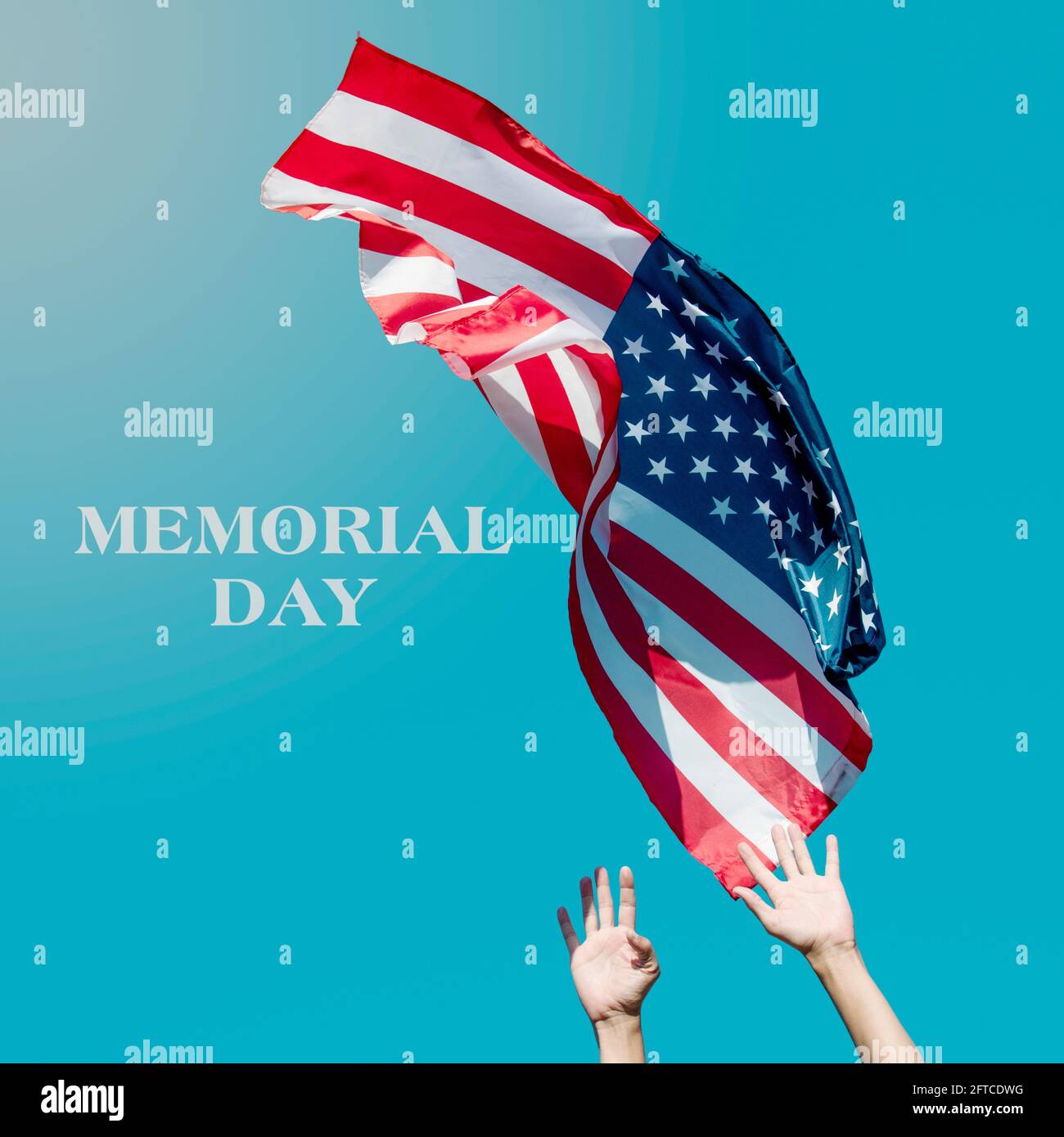 the text memorial day and a young caucasian man launching a flag of the United States to the blue sky, or about to catch it as it flights in the air Stock Photo