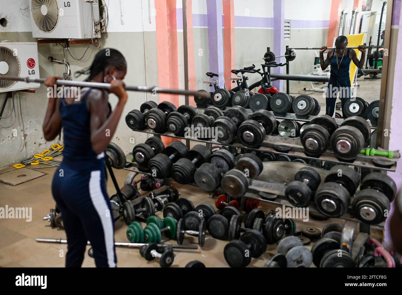 SENEGAL, Thies, gym, fitness and body building Studio, young woman doing training with weight lifting / junge Frau im Fitness Studio, Training mit Gewichte heben Stock Photo